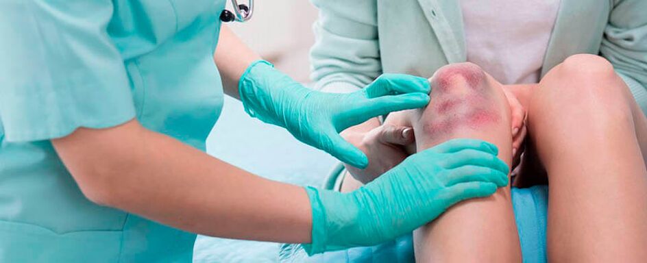 un médico examina unha lesión no xeonllo
